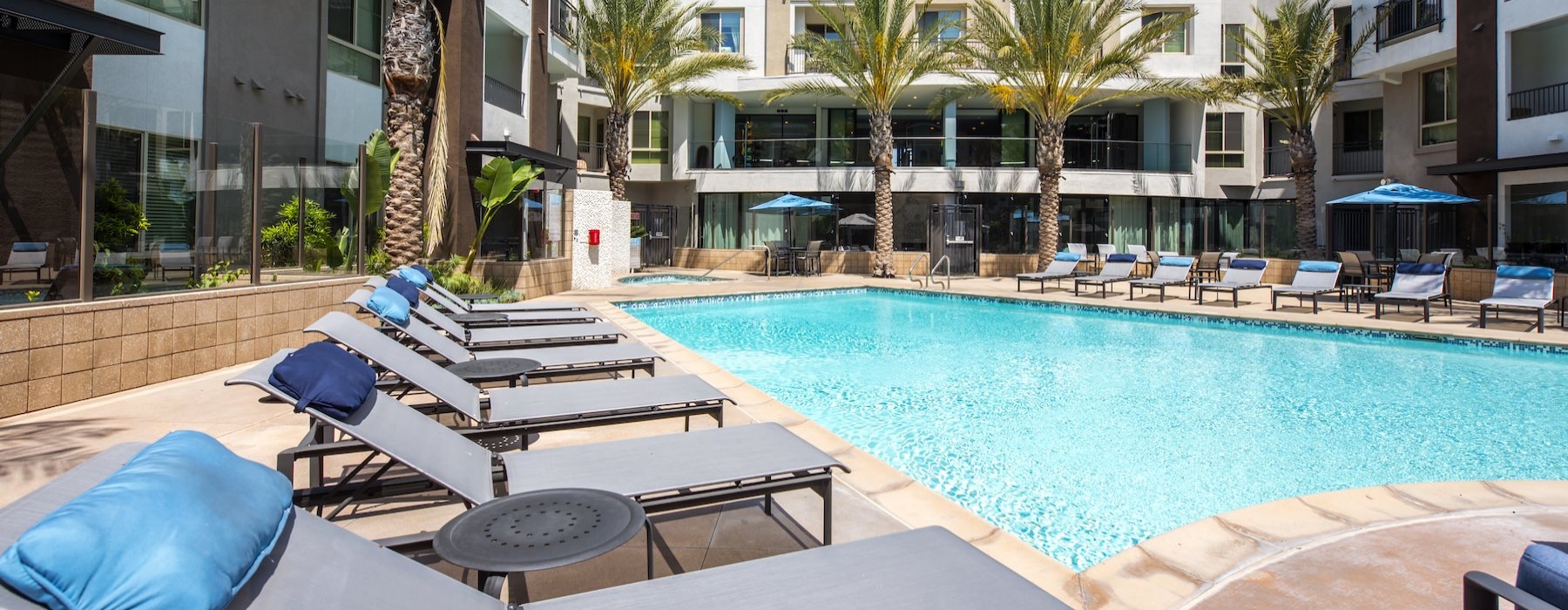 a pool with lounge chairs and tables by it