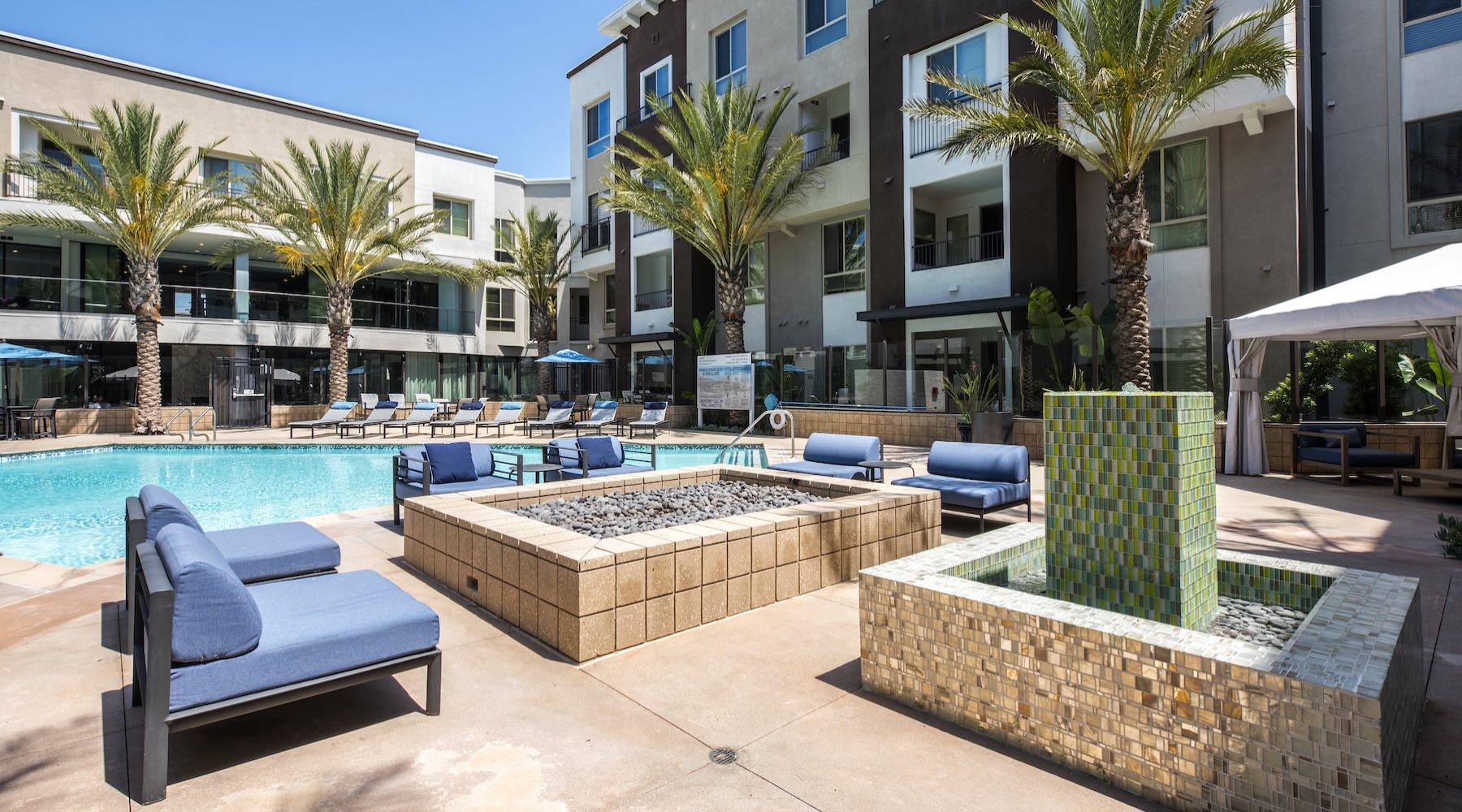 a fire pit with chairs and a pool