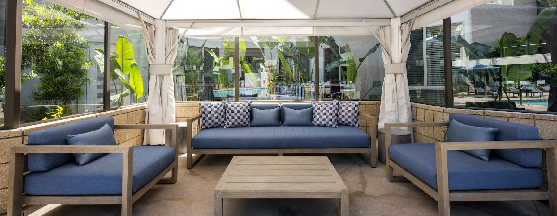 a covered patio with a coffee table and couches